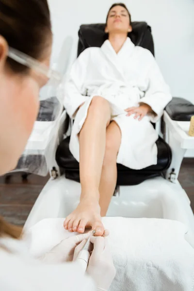 Junge Frau macht Pediküre im Salon. Schönheitskonzept. — Stockfoto