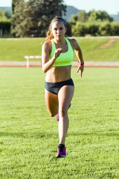 Ajuste jovem correndo no campo de atletismo . — Fotografia de Stock