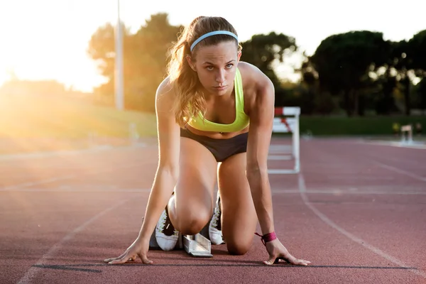 Unga kvinnliga idrottare lansering av startlinjen i ett lopp. — Stockfoto