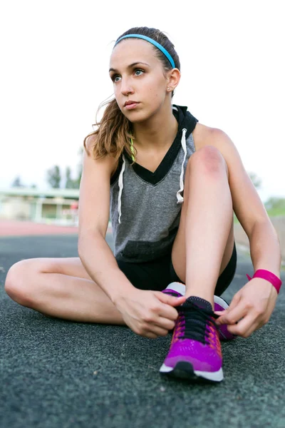 Junge Frau entspannt sich nach Lauf auf Stadion-Rennstrecke. — Stockfoto