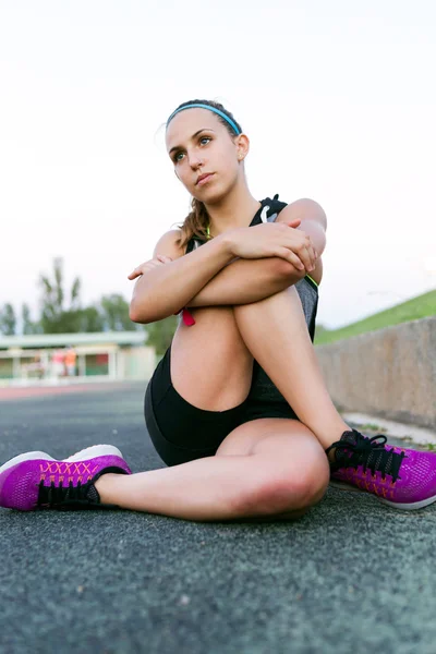 Schöne junge Frau dehnt sich und bereitet sich auf das Laufen auf tr vor — Stockfoto