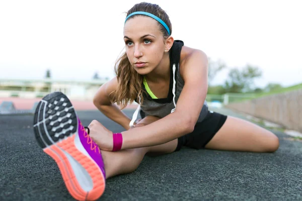 Hermosa joven mujer estirándose y preparándose para correr en tr —  Fotos de Stock