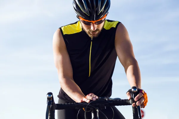 De timer van de instellen van jonge fietser man op fiets in sportkleding. — Stockfoto