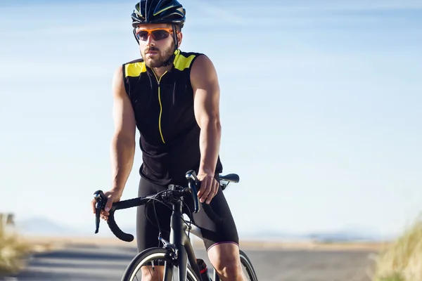 Bonito jovem fazendo uma pausa depois de um treinamento de ciclismo sessi — Fotografia de Stock