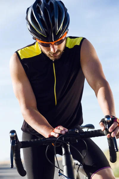 Junger Radler setzt Zeitschaltuhr auf Fahrrad in Sportkleidung. — Stockfoto