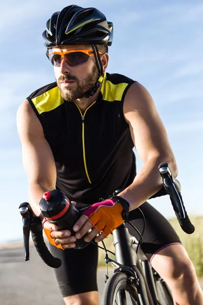 Bonito jovem fazendo uma pausa depois de um treinamento de ciclismo sessi — Fotografia de Stock