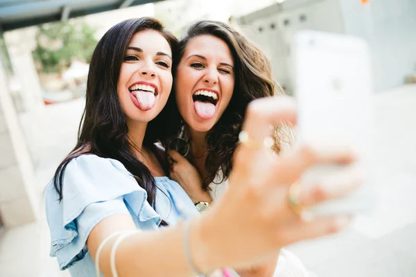 Belles jeunes femmes prenant un selfie dans la rue . — Photo