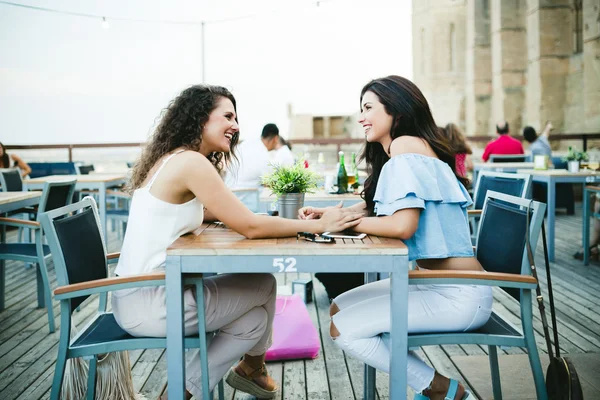 Beautiful young women talking in a restaurant terrace. — Stock Photo, Image