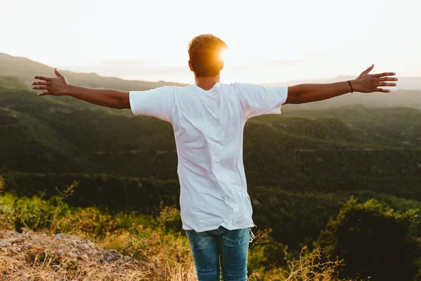 Stilig ung man som njuter av naturen på bergstopp. — Stockfoto