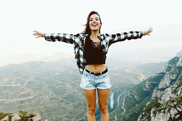 Beautiful young woman enjoying nature at mountain peak. — Stock Photo, Image