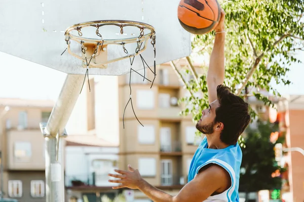 Retrato de jovem bonito jogando basquete na quadra . — Fotografia de Stock