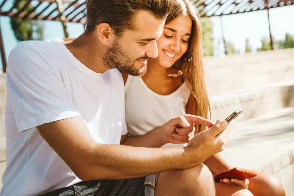 Portrét krásného mladého páru pomocí mobilního telefonu. — Stock fotografie