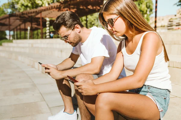 Retrato de hermosa pareja joven usando teléfono móvil . —  Fotos de Stock