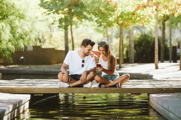 Portret van mooie jonge paar gebruik mobiele telefoon. — Stockfoto