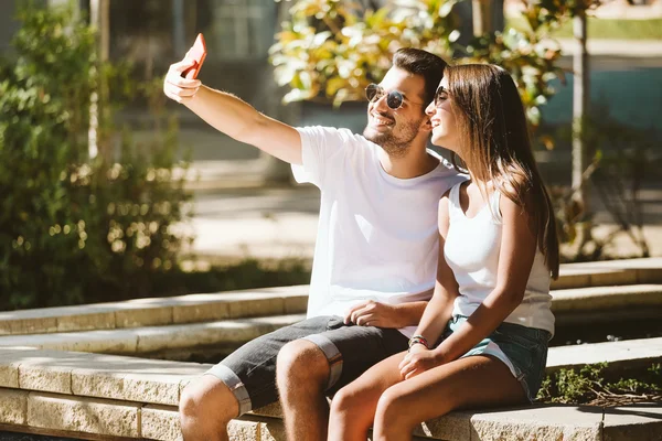 Retrato de belo jovem casal usando telefone celular . — Fotografia de Stock