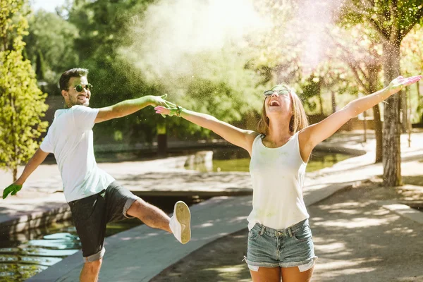 Schönes junges Paar spielt im Park auf Holi Colors Festival. — Stockfoto