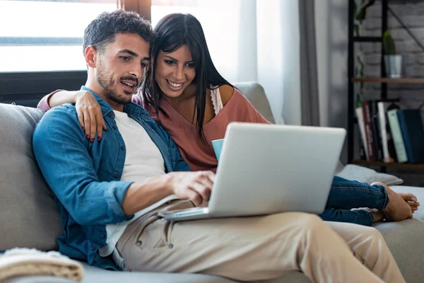 Tiro Casal Bonito Feliz Usando Computador Enquanto Sentado Sofá Casa — Fotografia de Stock