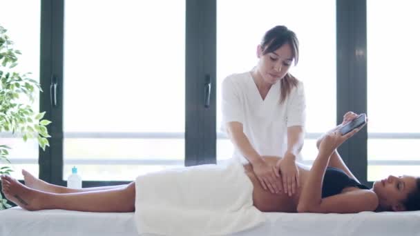 Video Bella Giovane Fisioterapista Donna Massaggiare Pancia Sulla Donna Incinta — Video Stock