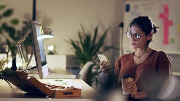 사무실에 컴퓨터로 일하는 핸드폰으로 비디오를 아름다운 사업가의 — 비디오