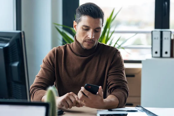 Tiro Belo Jovem Empreendedor Enviando Mensagens Com Telefone Inteligente Enquanto — Fotografia de Stock