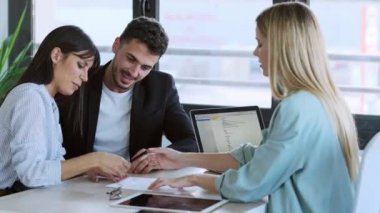 Emlakçıyla banka kredisi anlaşması imzalayan mutlu genç çiftin ofisteki evi satın alma videosu..