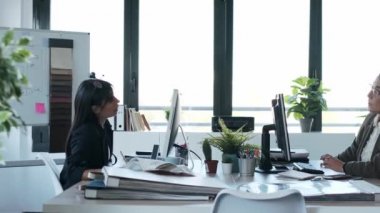 Ofiste bilgisayarlı bir tasarım projesinde çalışan iki güzel tasarımcı kadının videosu..