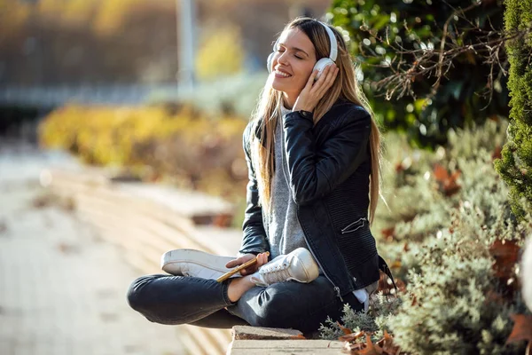 Skott Leende Ung Kvinna Lyssnar Musik Med Smartphone När Sitter — Stockfoto