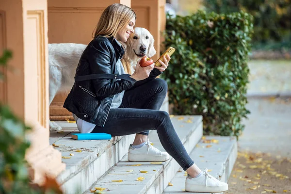 Sonbaharda Güzel Köpeğiyle Parkta Otururken Akıllı Telefonuyla Mesaj Gönderen Güzel — Stok fotoğraf