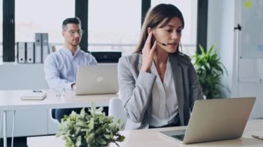 Çekici ve zeki iş adamlarının çeşitli iş arkadaşlarıyla iş yerindeki bilgisayarla online brifing hakkında video görüşmesi yaparken.