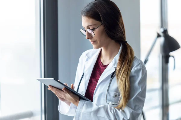 病院の診察でデジタルタブレットを使用している集中若い女性医師のショット — ストック写真