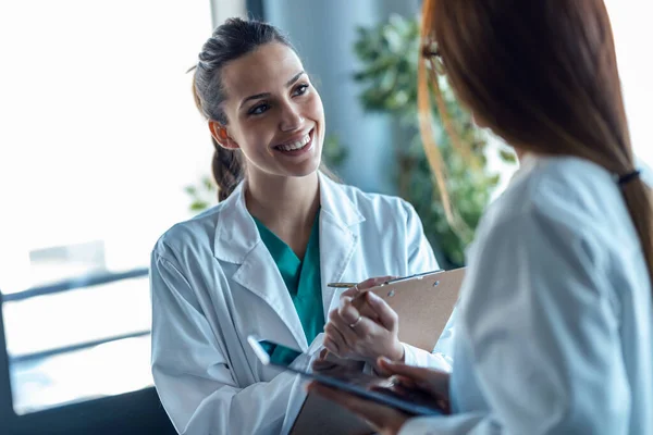 Fotografía Hermosa Joven Doctora Hablando Con Colega Mientras Mira Tableta —  Fotos de Stock