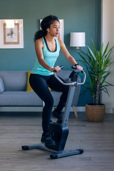 Shot Sporty African Young Woman Exercising Smart Stationary Bike Listening — Stock Photo, Image