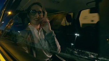 Şoför onu gece eve götürürken akıllı telefonuyla konuşan güzel, olgun bir iş kadınının videosu..