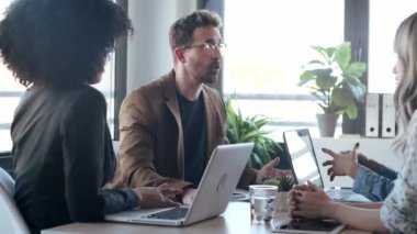 Ofiste yeni projelerinden bahsederken dizüstü bilgisayarlarla çalışan sıradan iş adamlarının videosu..