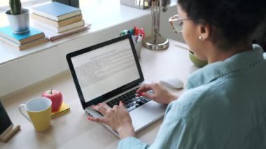 Bilgisayarla çalışan güzel afro iş kadınının videosu evde ofiste oturuyor..