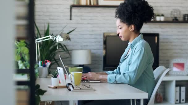 Videó gyönyörű fiatal afro üzleti nő dolgozik laptop ül az irodában otthon.