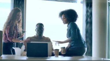 Birlikte çalıştıkları yerde yeni projelerden bahsederken dizüstü bilgisayarlarla çalışan çok ırklı iş adamlarının videosu.