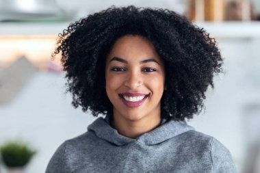 Evdeki mutfakta kameraya bakan gülümseyen genç iş kadınının portresi..