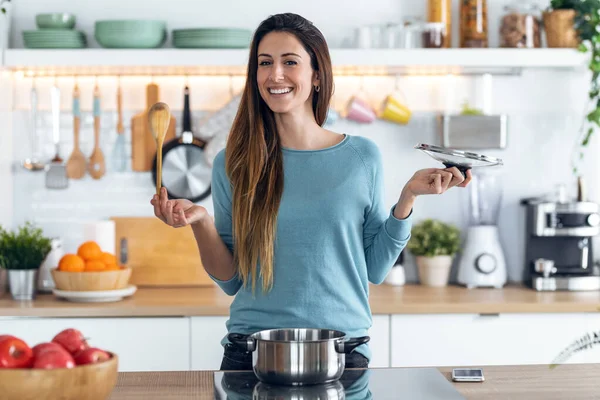 Tiro Mujer Joven Feliz Cocinando Comida Saludable Cazuela Mientras Siembra —  Fotos de Stock