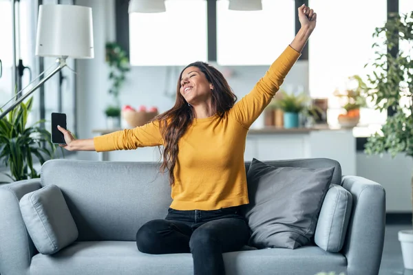 Shot Pretty Young Woman Stretching While Relaxing Sitting Couch Living — Fotografia de Stock