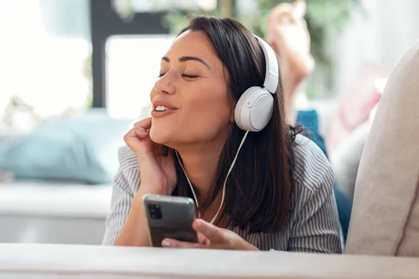 Tiro Moça Motivada Ouvindo Música Com Smartphone Enquanto Sentada Sofá — Fotografia de Stock