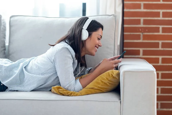 Tiro Jovem Sorridente Ouvindo Música Com Smartphone Enquanto Estava Sentado — Fotografia de Stock