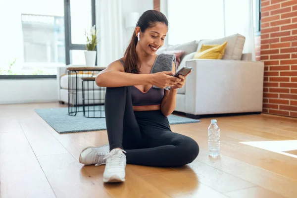 Tiro Jovem Desportiva Usando Seu Telefone Celular Enquanto Segurando Garrafa — Fotografia de Stock