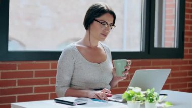 Evde bilgisayarla çalışan genç iş kadınının videosu..