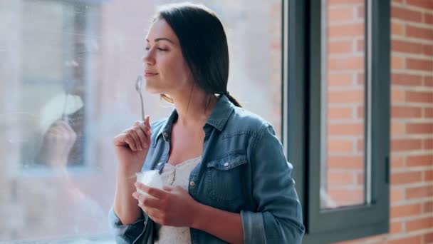 Video Hermosa Mujer Negocios Comiendo Yogur Mientras Está Pie Cerca — Vídeos de Stock