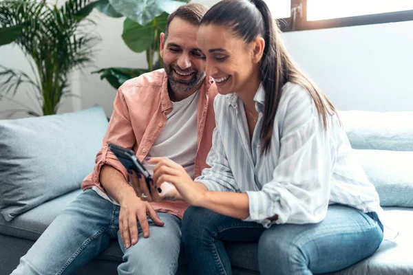 Tiro Feliz Pareja Joven Buscando Fotos Teléfono Inteligente Mientras Divierten — Foto de Stock