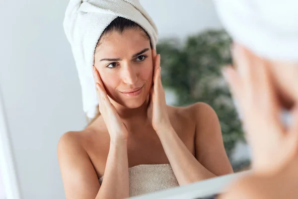 Retrato Una Hermosa Joven Cuidando Piel Mientras Pone Crema Mirando — Foto de Stock