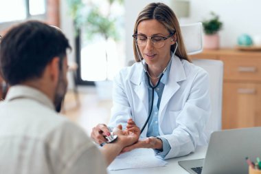 Muayenehanede hastaya ilaç yazarken, tıbbi tedaviyi açıklarken güzel olgun kadın doktorların konuşması..