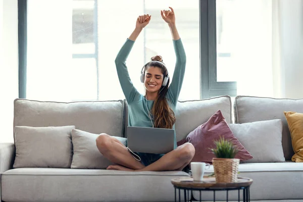 소파에 여자가 노트북으로 음악을 — 스톡 사진
