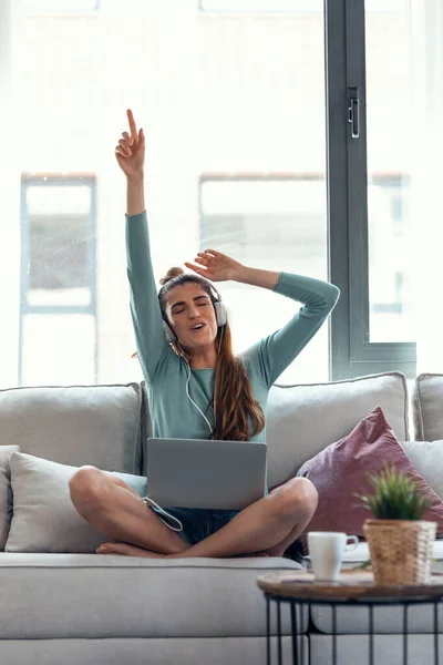 소파에 여자가 노트북으로 음악을 — 스톡 사진
